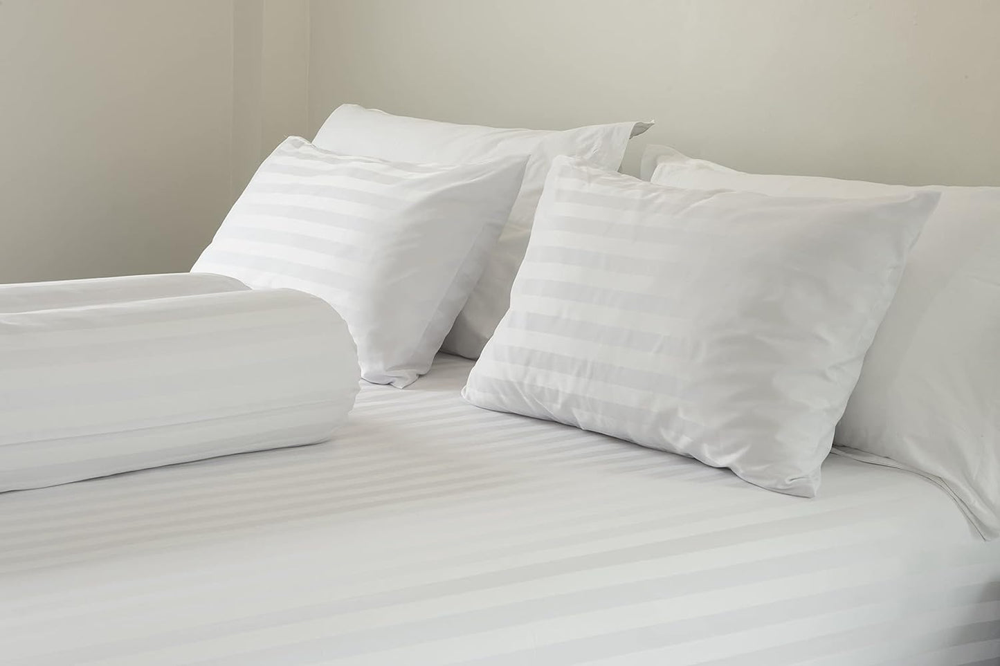 Two striped white pillows neatly arranged on a bed, enhancing the bedroom's aesthetic with a stylish touch of sophistication and comfort